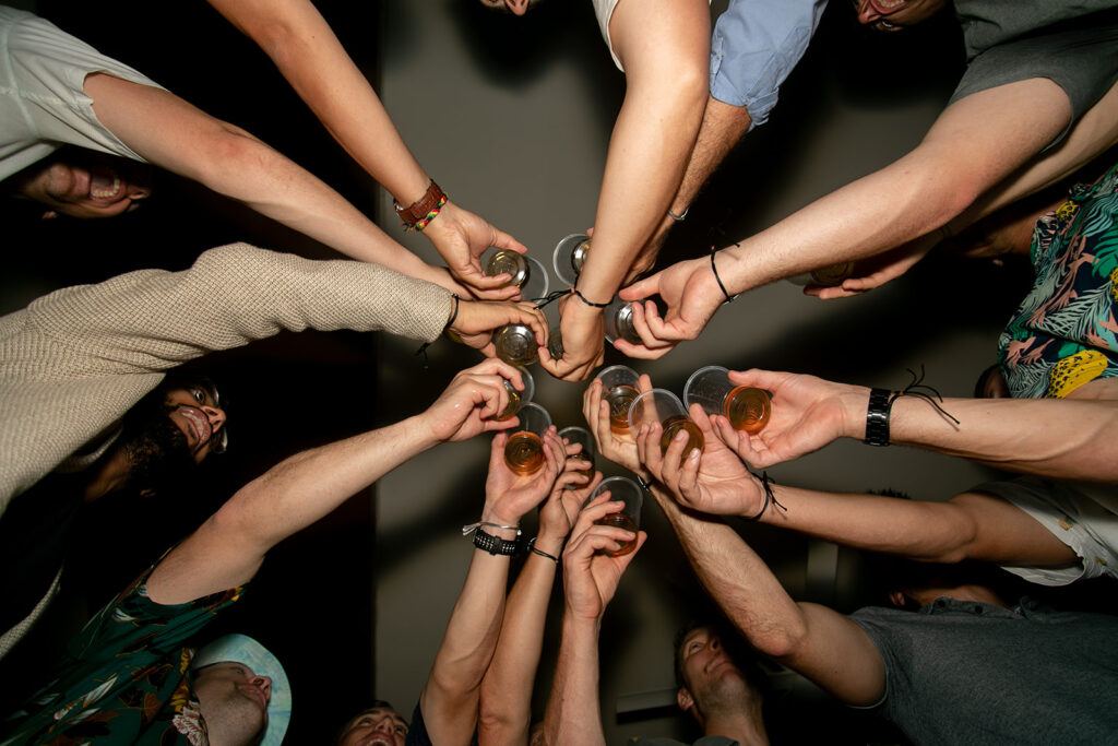 Group shot from below of everyone putting their arms in for a celebratory toast.