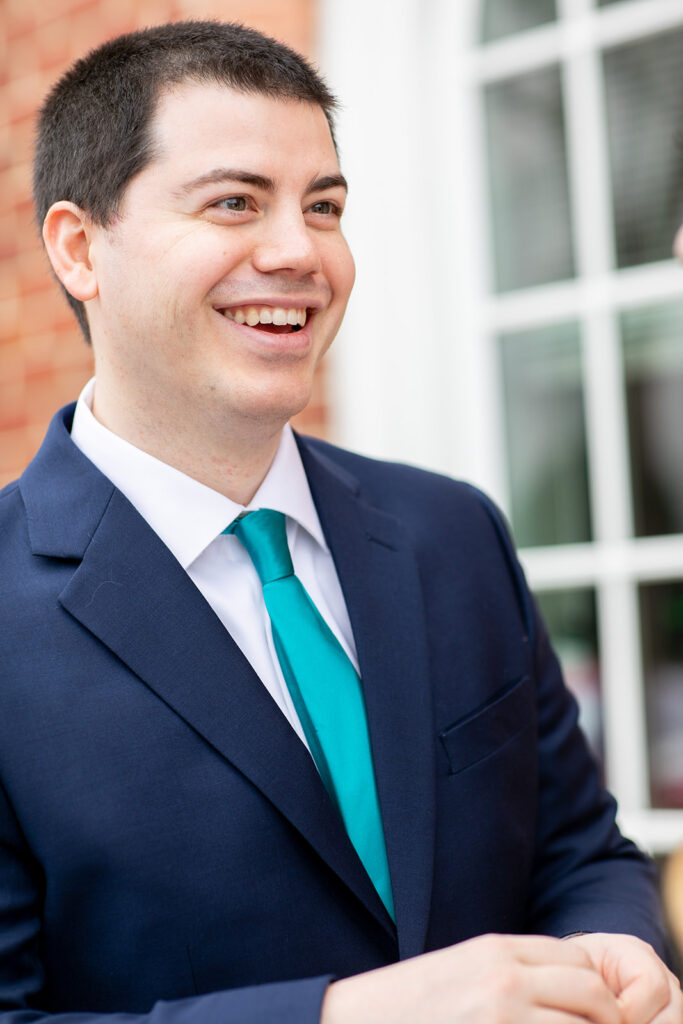 Groom laughing during portraits outside the Fredericksburg courthouse.