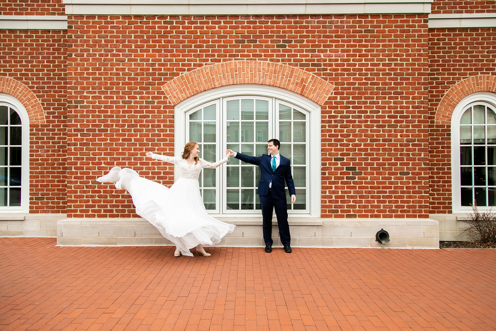 Groom giving his bride a twirl outside of a downtown courthouse just after their courthouse wedding.