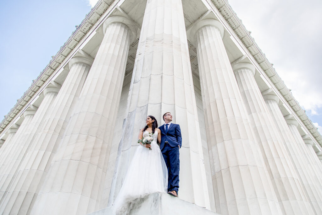 Bride and groom standing between the Lincoln Memorial columns during a Washington DC elopement