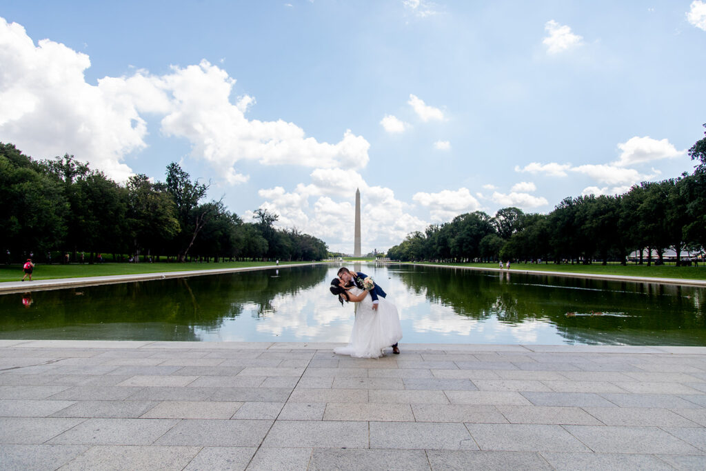 Wide view of the DC War Memorial elopement with the Washington Monument reflected in the pool