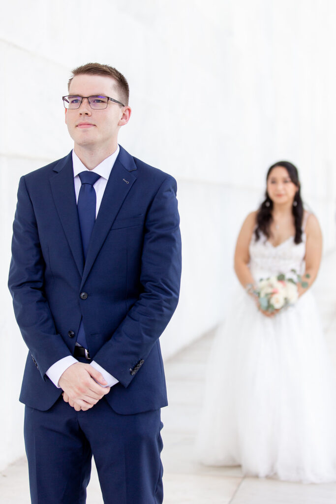 Groom waiting during first look at the Lincoln Memorial in Washington DC elopement
