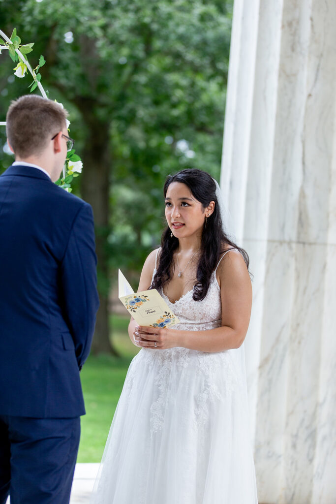 Bride holding her vow book while exchanging vows during a DC War Memorial elopement
