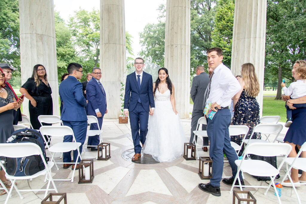 Bride walking down the aisle with guests during an intimate DC War Memorial elopement ceremony