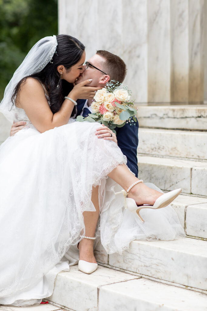 Bride and groom sitting together on the steps of the DC War Memorial after their elopement