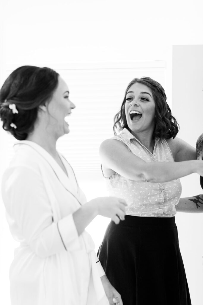Bride laughing with close friends during getting ready moments at an intimate Alexandria wedding.