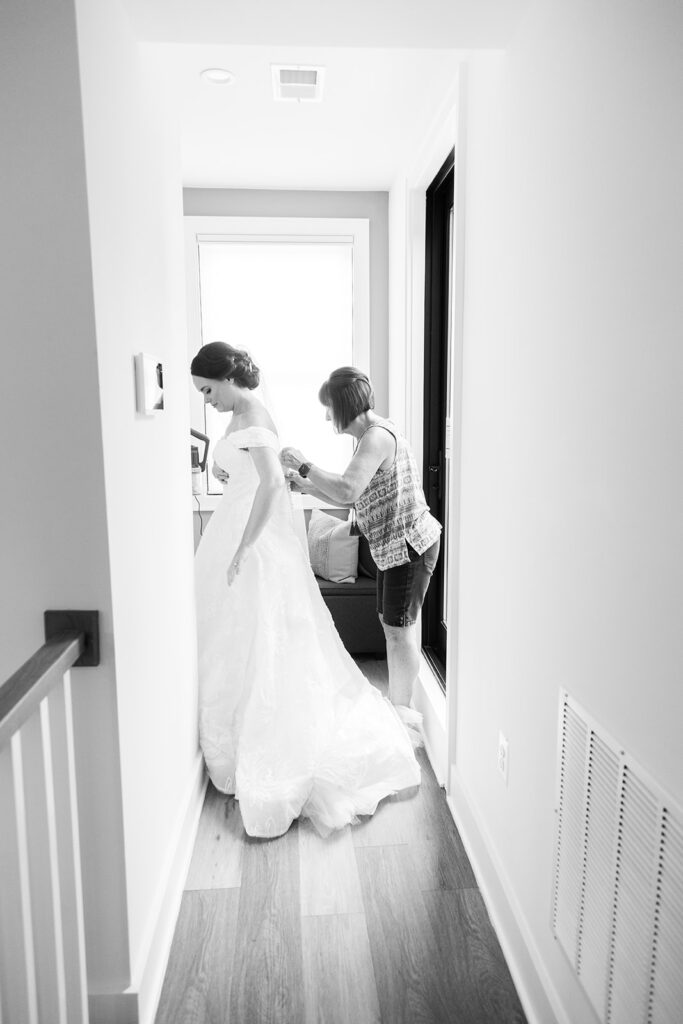 Bride being helped into her wedding dress by close loved ones during getting ready in downtown Alexandria.
