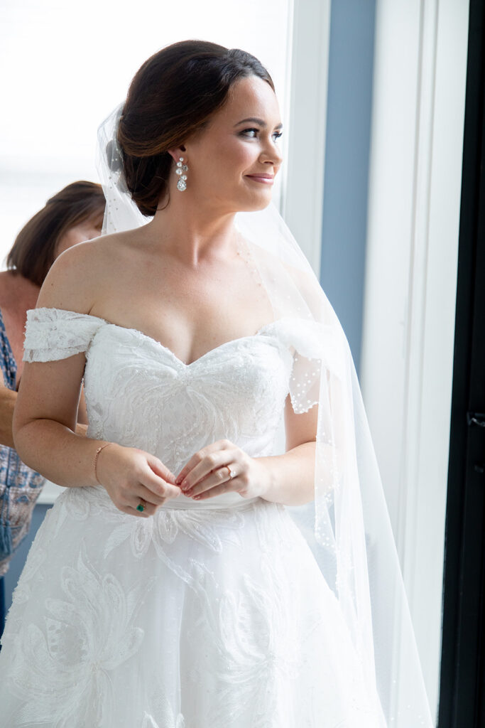 Bride standing by a window while getting ready for her intimate wedding in Alexandria, Virginia.
