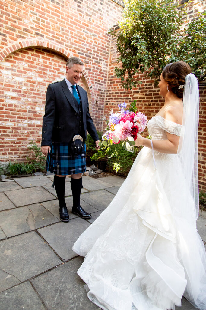 Groom wearing traditional Scottish attire during a first look with the bride in Alexandria.