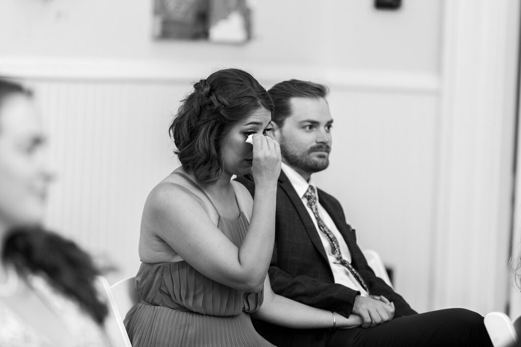 Wedding guest wiping away tears during an intimate Athenaeum wedding ceremony in Alexandria.