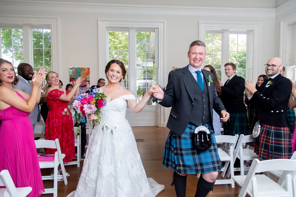 Bride and groom walking back up the aisle after their wedding ceremony at the Athenaeum in Alexandria.