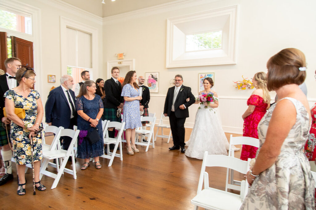 Wedding guests standing as the bride enters the Athenaeum during an intimate Alexandria wedding ceremony.