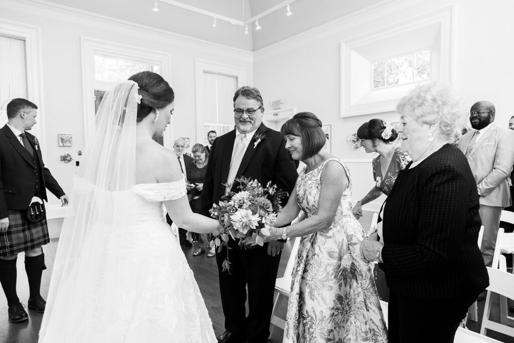 Bride sharing a meaningful moment with family during the wedding ceremony at the Athenaeum in Alexandria.