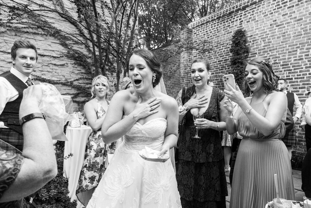 Bride reacting joyfully with guests during cocktail hour at the Athenaeum in Alexandria.