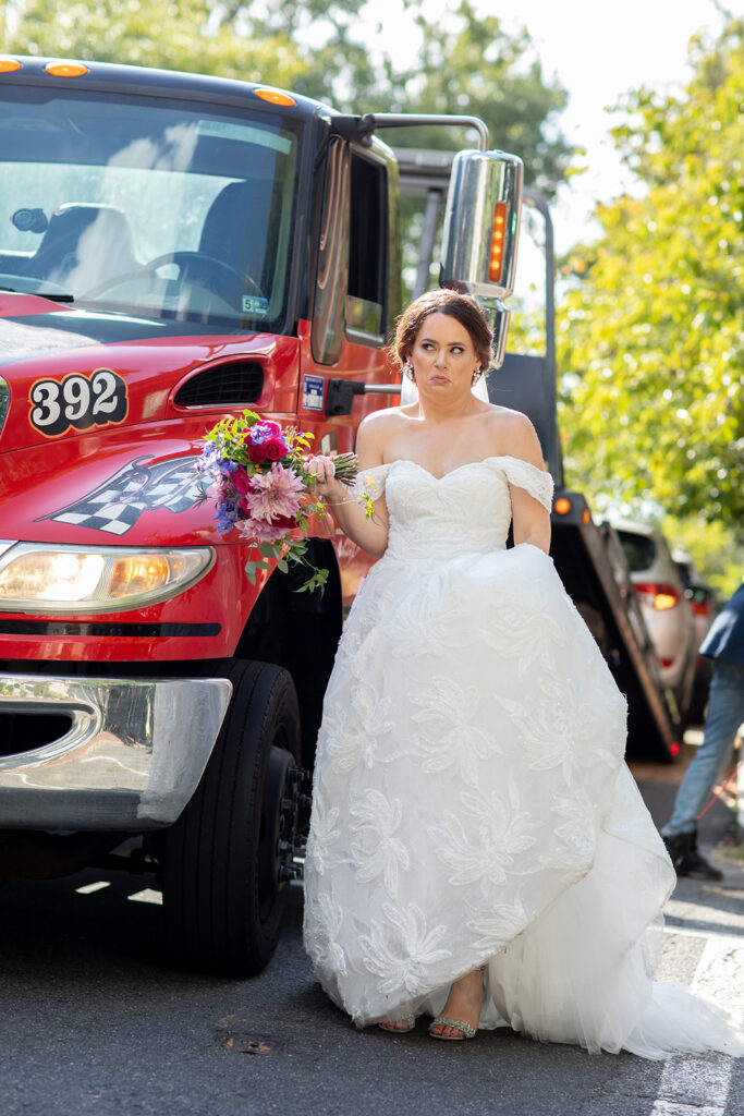 Bride standing in front of a tow truck during her intimate wedding day in downtown Alexandria.