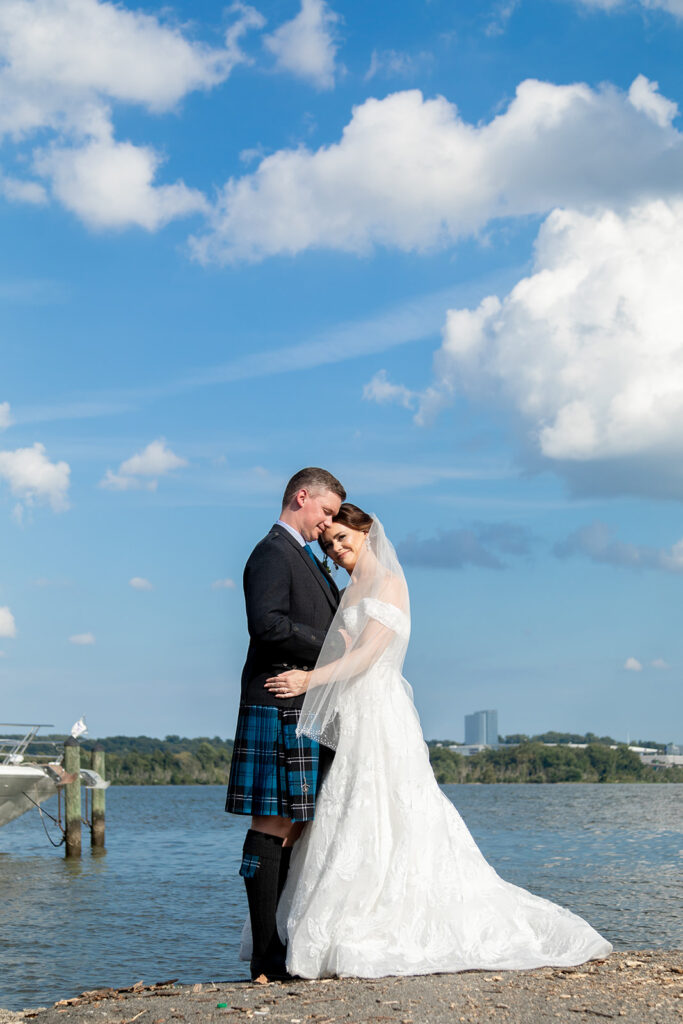 Bride and groom embracing during waterfront wedding portraits in downtown Alexandria.
