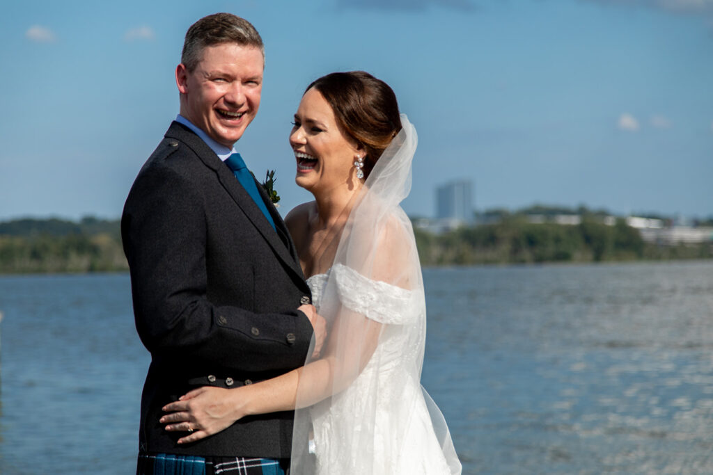 Bride and groom laughing together during downtown Alexandria waterfront wedding portraits.