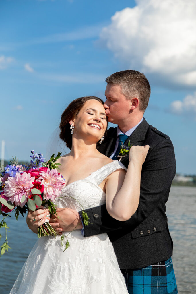Groom kissing the bride during downtown Alexandria waterfront wedding portraits.