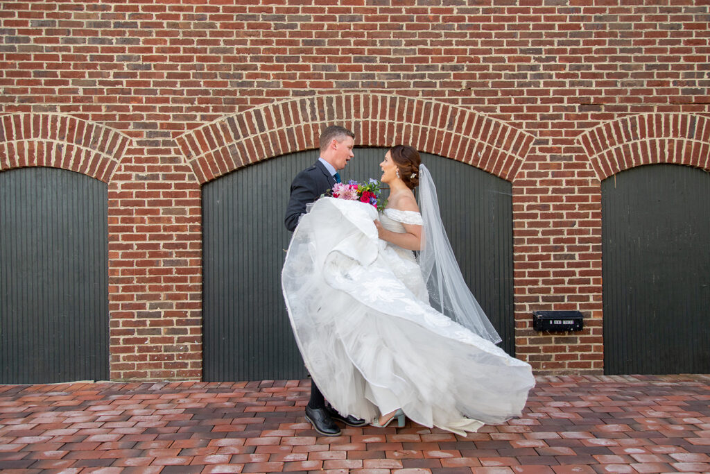 Groom lifting the bride during downtown Alexandria wedding portraits.