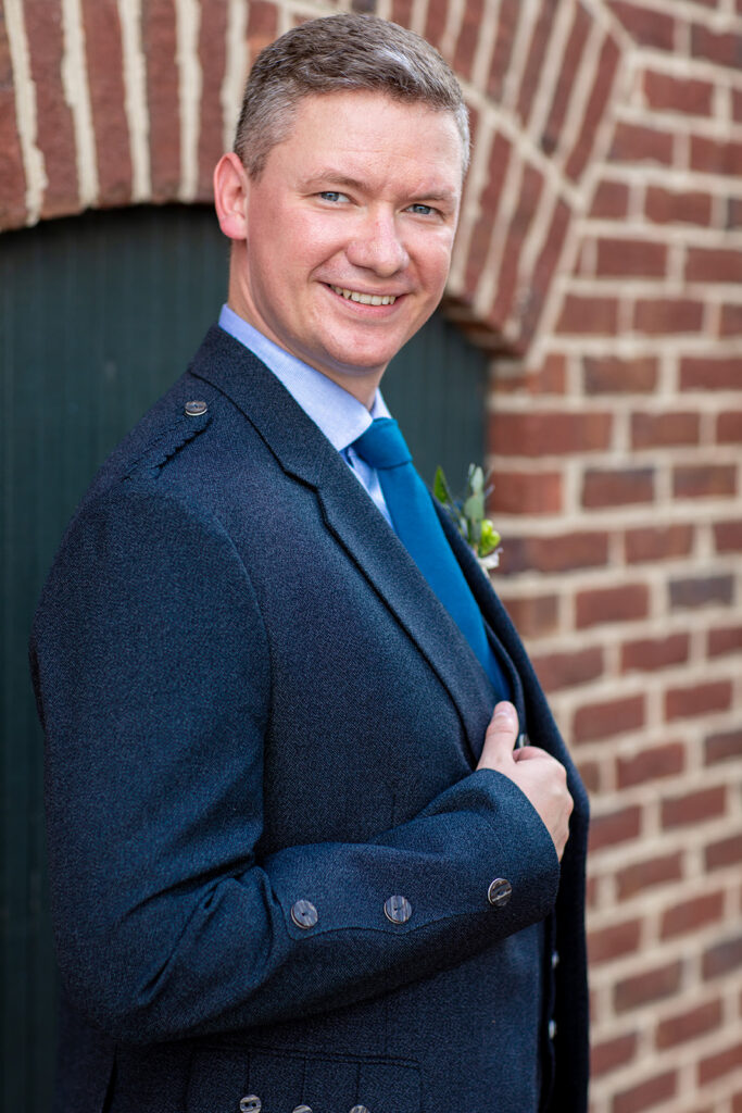 Groom smiling during downtown Alexandria wedding portraits.