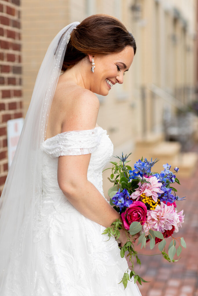 Bride looking down and laughing during downtown Alexandria wedding portraits.