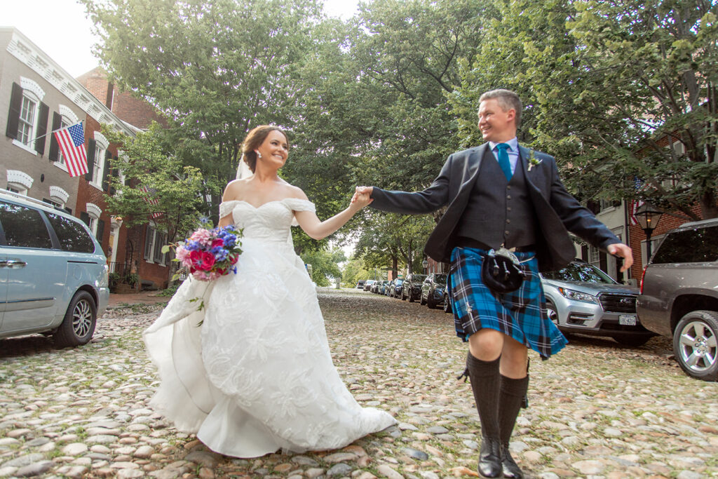 Bride and groom walking together through downtown Alexandria during wedding portraits.