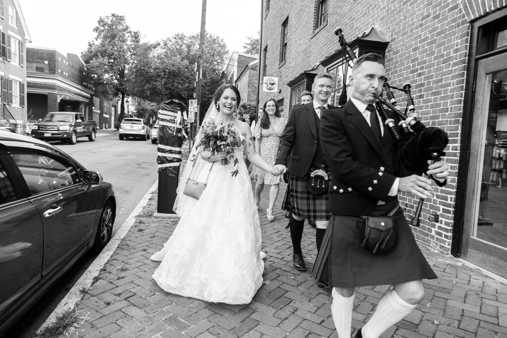 Bride and groom walking through downtown Alexandria with guests during their wedding celebration.