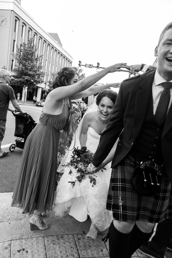 Bride laughing while walking through a downtown Alexandria wedding processional.