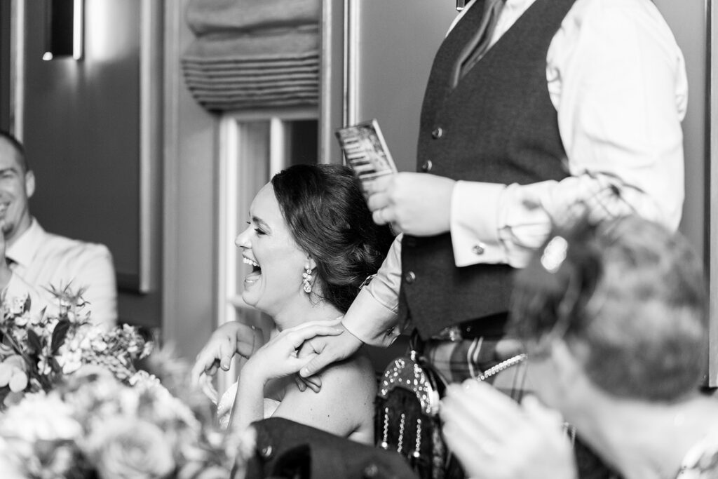 Bride laughing during a wedding toast at the Morrison House reception in Alexandria.