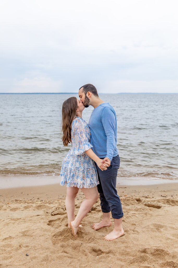 DC couple standing along the shoreline during a beach engagement session at Terrapin Nature Park
