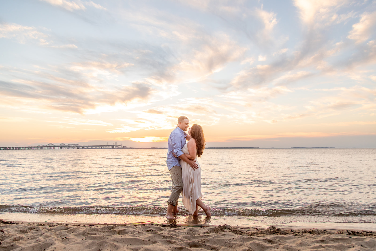 Hope and Tyler hugging on the beach with a dramatic sunset sky at Terrapin Nature Park.